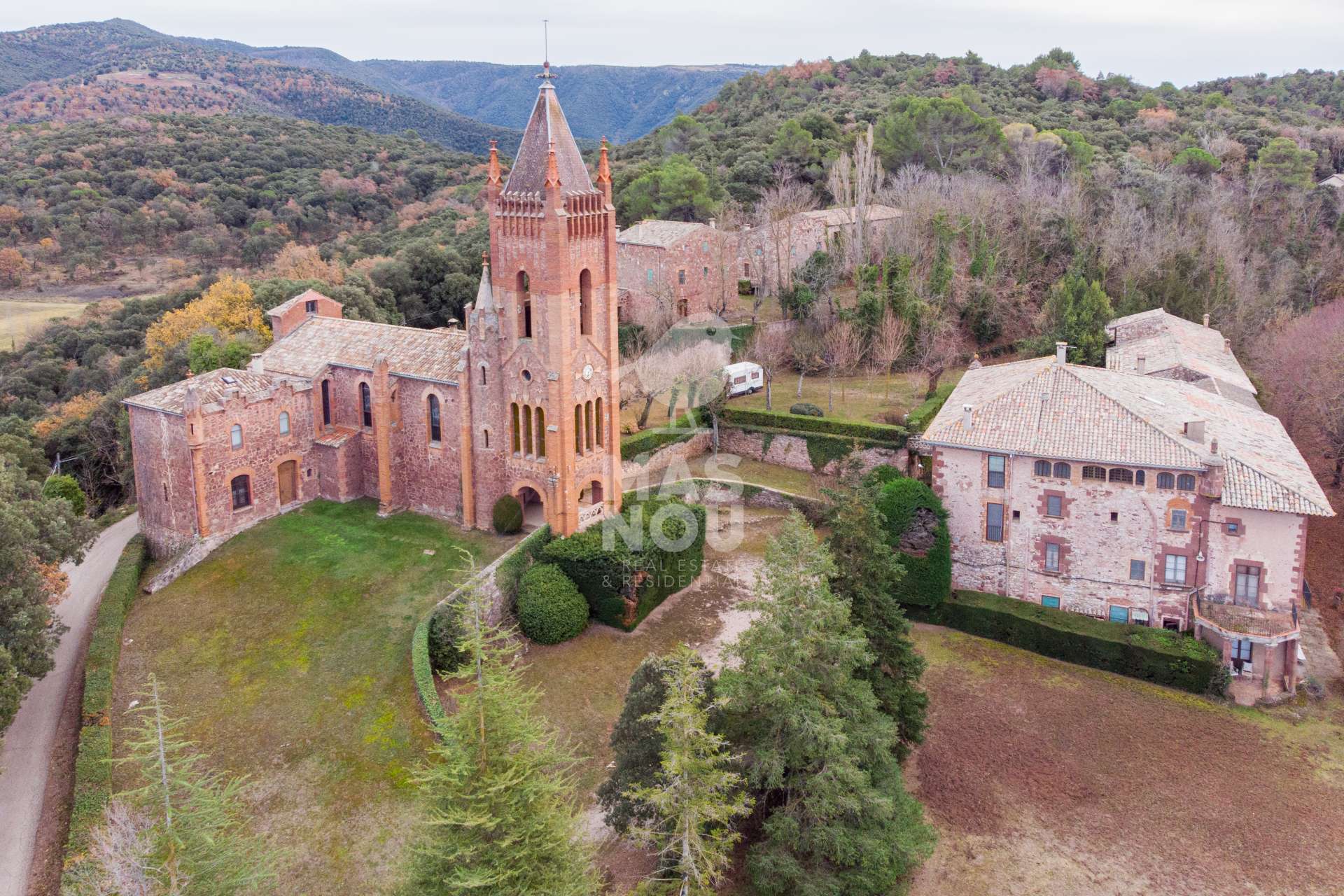 Impresionante vista aérea de una histórica iglesia de piedra enclavada entre colinas, inspiración perfecta para los viajeros que desean comprar hoteles España.